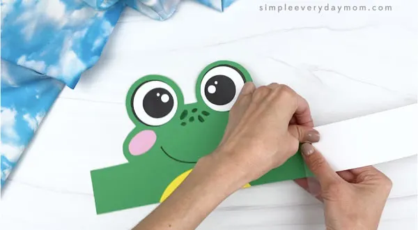 hands taping extenders to frog headband craft