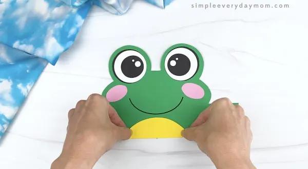 hand gluing belly to frog headband craft