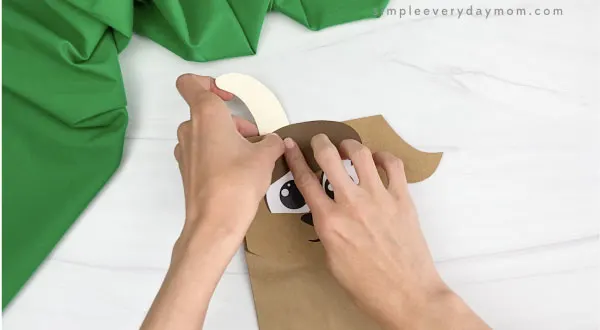 hand gluing horns to paper bag goat craft