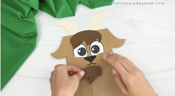 hand gluing goatee to paper bag goat craft
