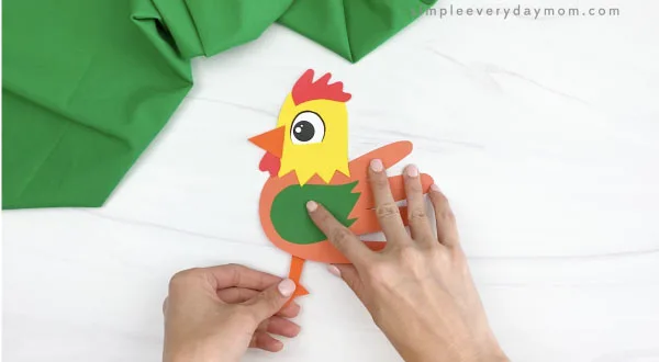 hand gluing legs to handprint rooster craft