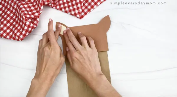 hand gluing inner ear to paper bag horse craft