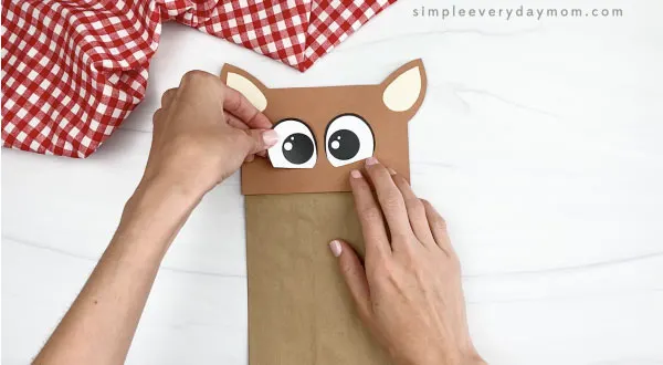 hand gluing eye to paper bag horse craft