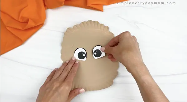 hand gluing eyes onto paper plate llama craft