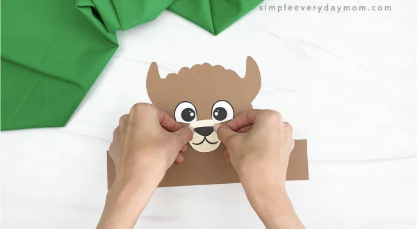 hand gluing nose and mouth to llama headband craft