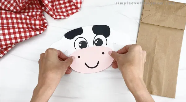 hand gluing mouth to paper bag cow craft