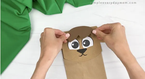 hand gluing hair to paper bag goat craft