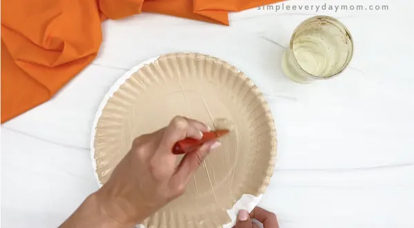 hand painting paper plate with light brown paint