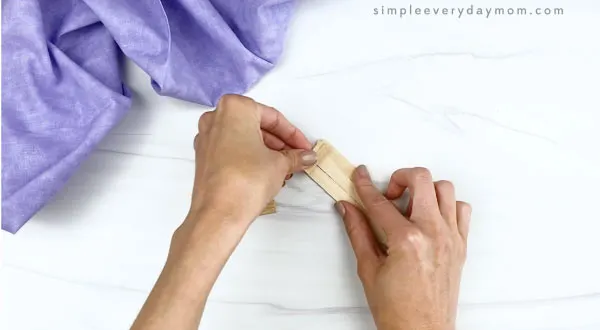 hand gluing popsicle stick together