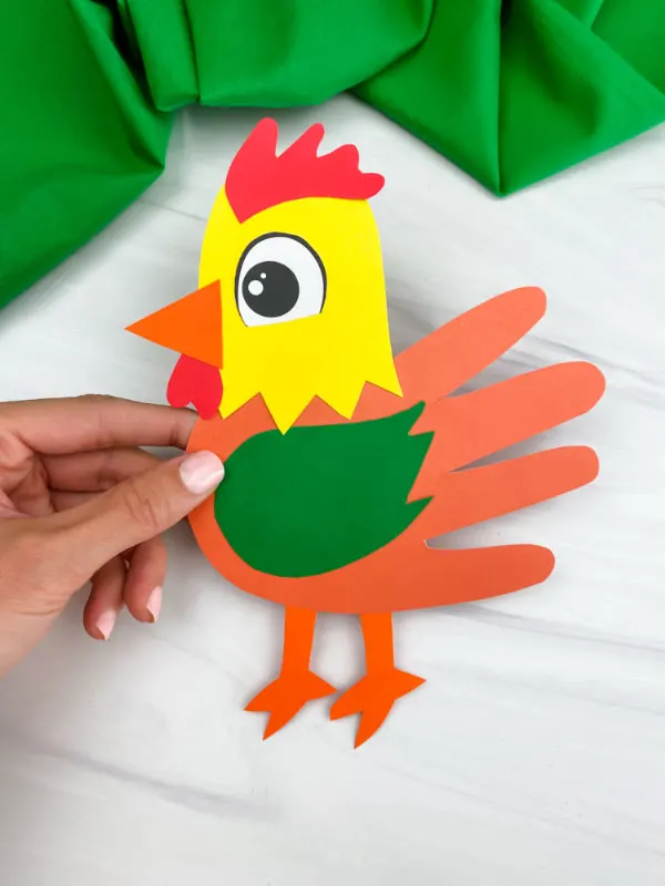 hand holding handprint rooster craft