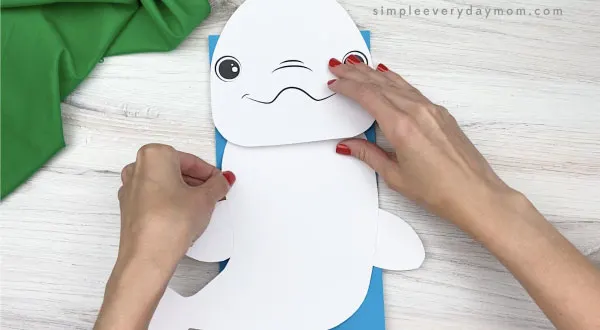 hand gluing body to paper bag beluga craft