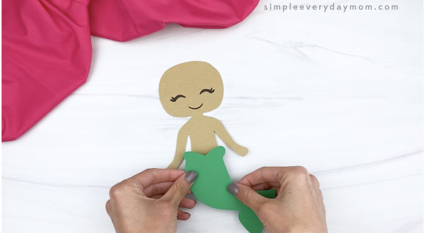 hand gluing tail to mermaid paper craft