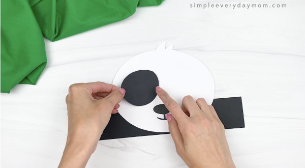 hand gluing eye spot to panda headband craft