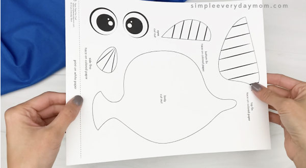 hand holding paper plate fish craft template