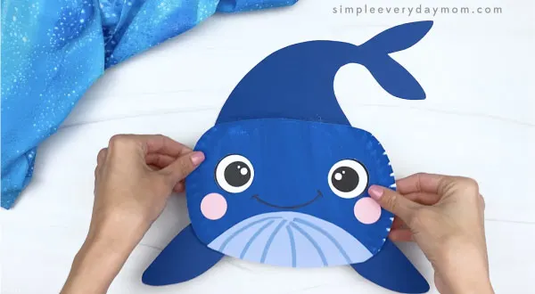 hand gluing tail onto paper plate whale craft