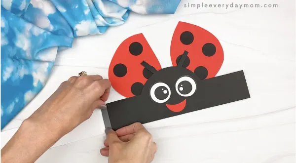 hand taping extender to ladybug headband craft