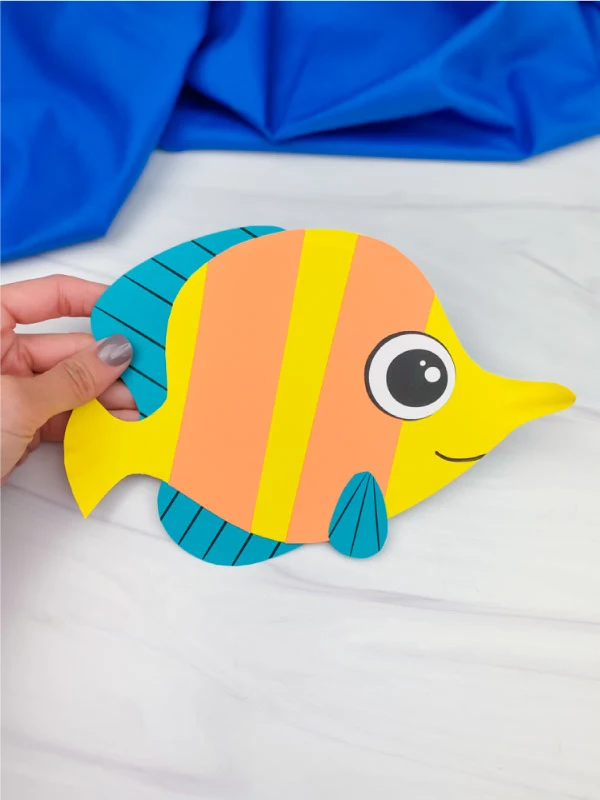 hand holding paper plate fish craft