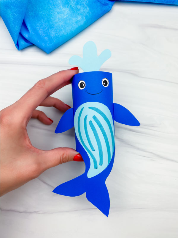 hand holding toilet paper roll humpback whale craft