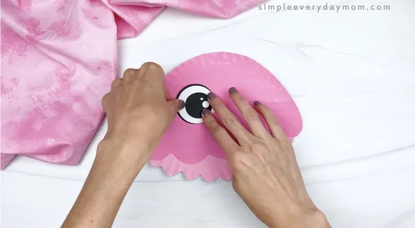 hand gluing eyes to paper plate jellyfish