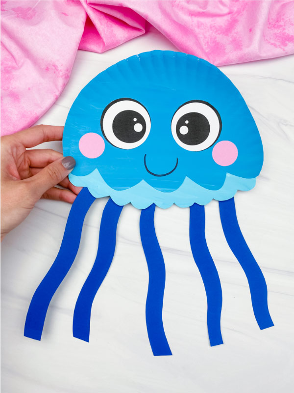 hand holding blue paper plate jellyfish