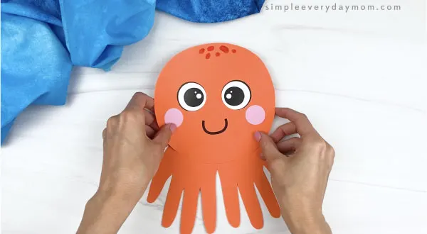 hand gluing head to handprint octopus