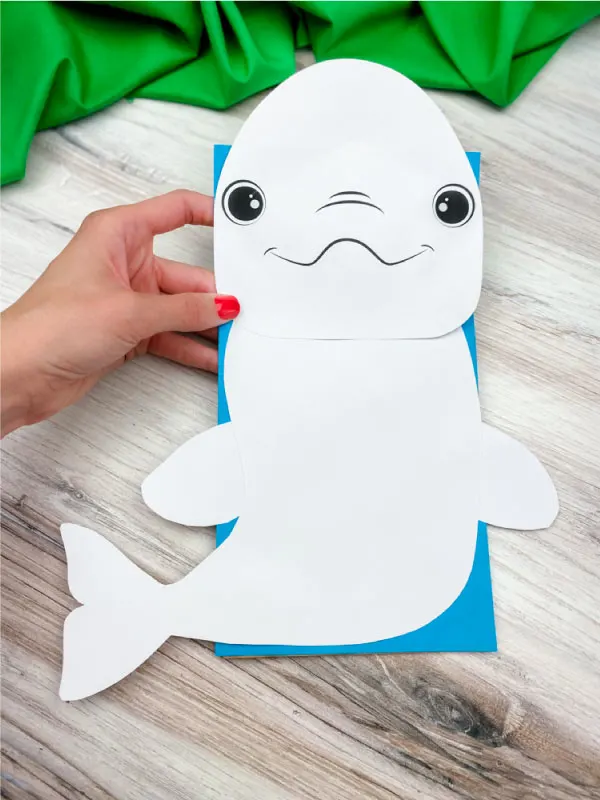 hand holding paper bag beluga whale craft