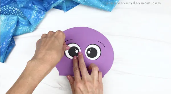hand gluing eyes to paper bag octopus craft