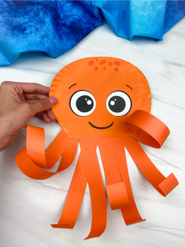 hand holding octopus paper plate craft