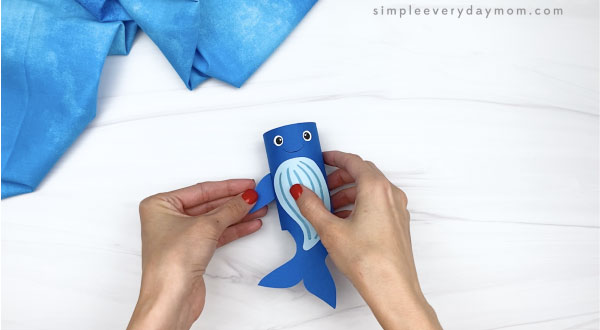 hand gluing fin to side of toilet paper roll humpback whale craft