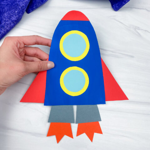 hand holding paper plate rocket craft