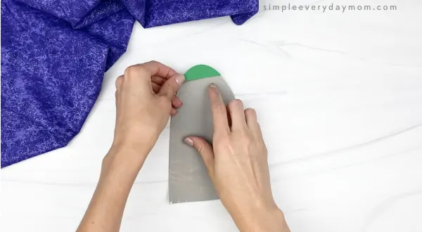 hand gluing tip to paper plate rocket craft
