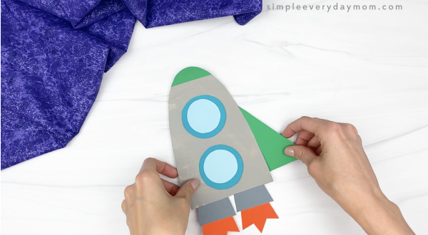 hand gluing fin to paper plate rocket craft
