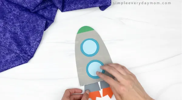 hand gluing engine to paper plate rocket craft