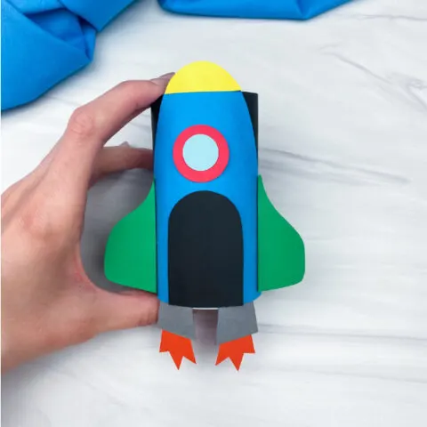 hand holding toilet paper roll rocket craft