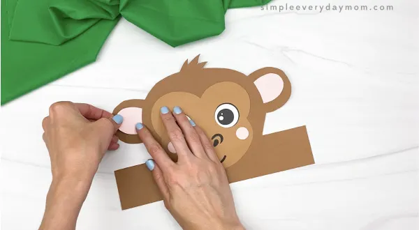 hand gluing inner ear to monkey headband craft