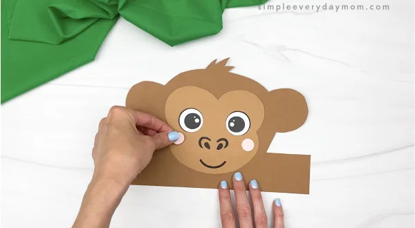 hand gluing cheek to monkey headband craft