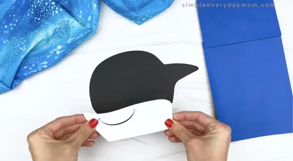 hand gluing mouth to killer whale paper bag craft