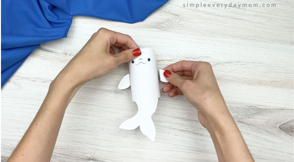 hand gluing fin to toilet paper roll beluga craft
