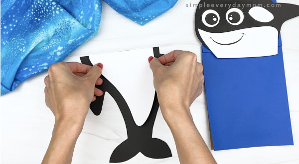 hand gluing belly to killer whale paper bag craft
