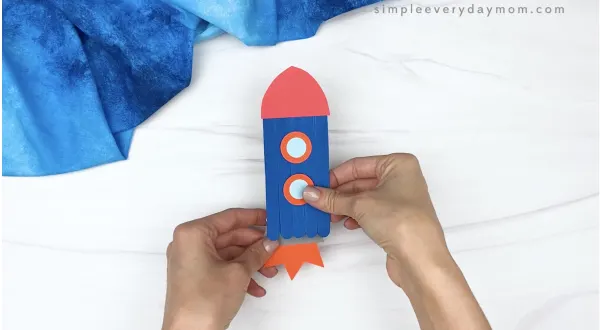 hand gluing flames to popsicle stick rocket craft