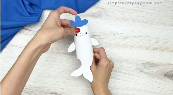 hand gluing water to toilet paper roll beluga craft