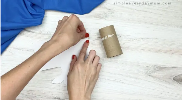 hand placing tape on paper roll beluga craft