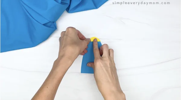 hand gluing tip onto toilet paper roll craft