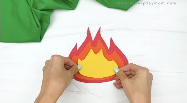 hand gluing yellow flame to paper campfire craft
