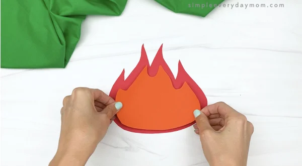 hand gluing orange flame to paper campfire craft