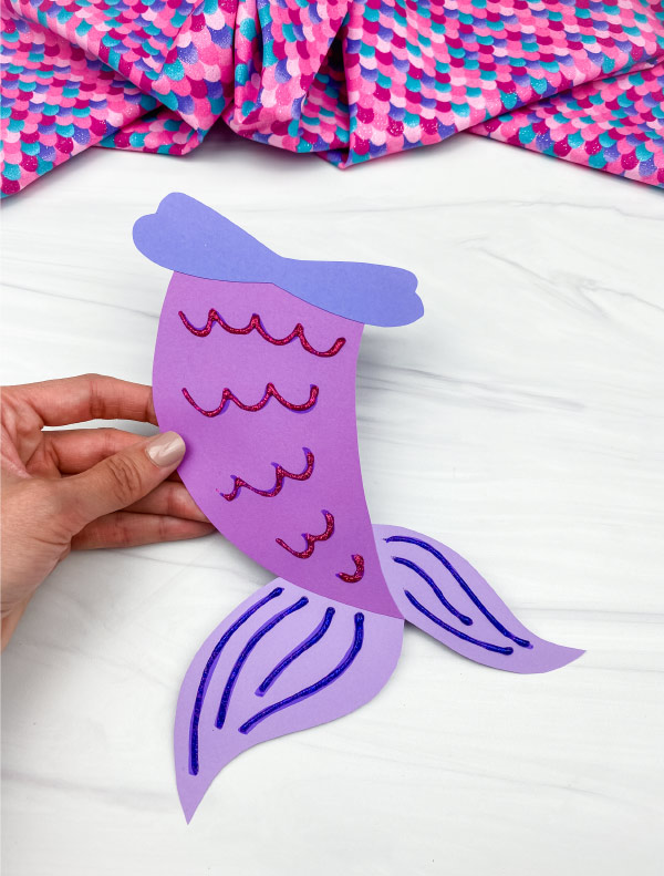 hand holding purple mermaid tail craft