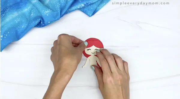 hand gluing bangs to toilet paper roll mermaid craft