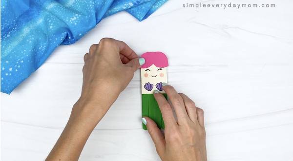 hand gluing bangs to popsicle stick mermaid craft