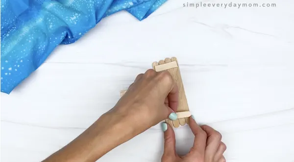 hand gluing popsicle stick together