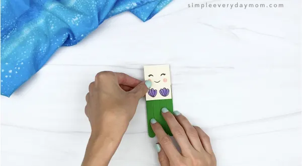 hand gluing body to popsicle stick mermaid craft